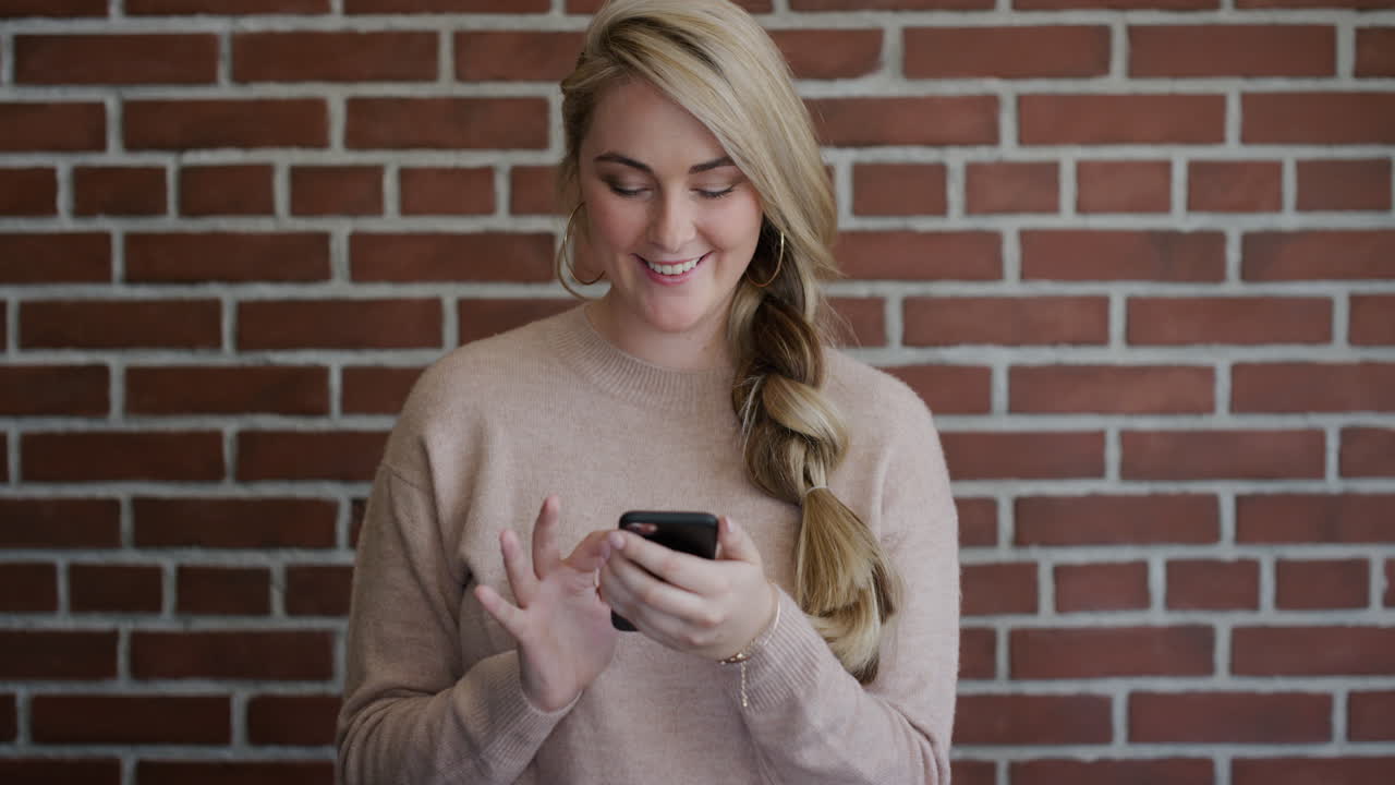 ritratto bella giovane donna bionda che usa lo smartphone navigando inviando messaggi di testo godendo della comunicazione mobile in slow motion