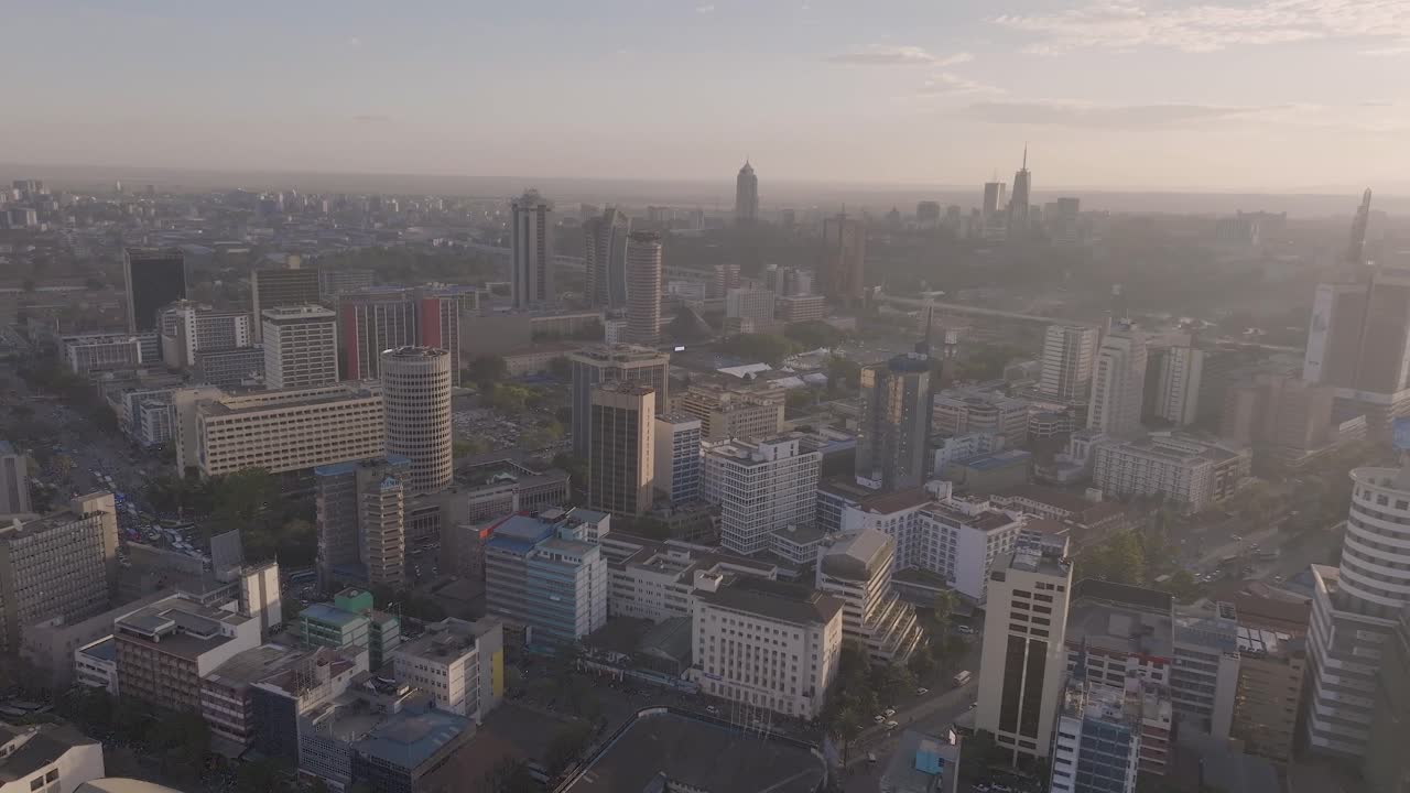 Panoramic aerial drone shot of Nairobi city with the sun setting showcasing the busy streets, matatus, buses, people, and building with the sun setting in the background