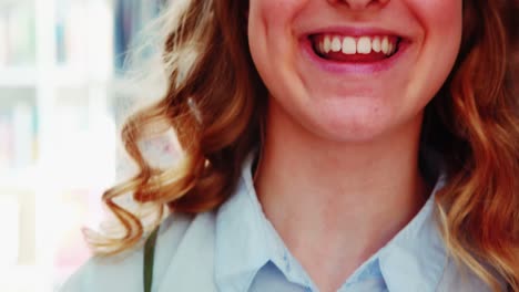 una colegiala sonriente leyendo un libro en la biblioteca