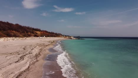 aerial shot close to water and sandy beach