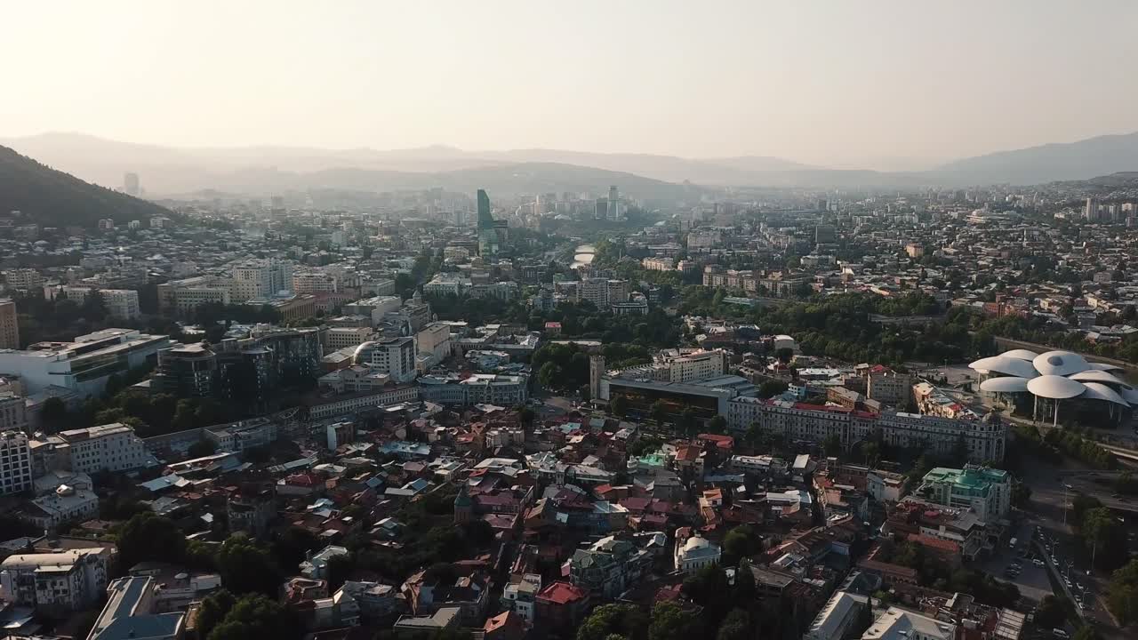 Veduta aerea del paesaggio urbano di Tbilisi in Georgia da drone in volo al tramonto.