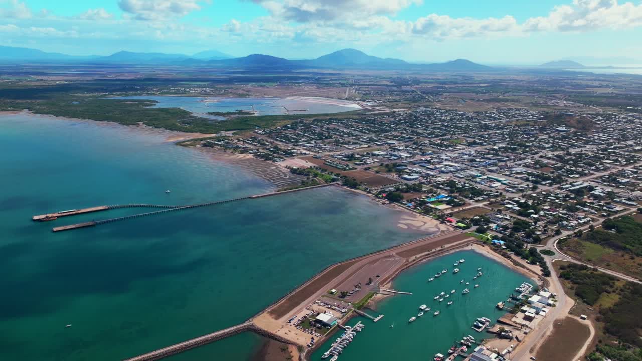 Paisaje aéreo con dron de la ciudad costera de Australia: Bahía McCanes, Proserpine, Muelle de Bowen, Bahía Horseshoe, Airlie Beach, cielo azul soleado, marina, barcos, coches, vista del puerto, Gran Barrera de Coral, Región de Whitsunday