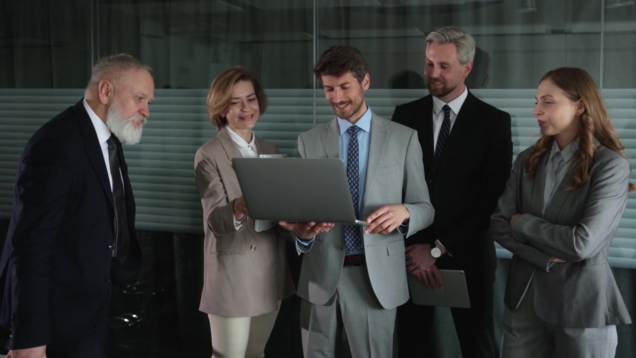 Business Team Collaborating and Discussing on Laptop in Office