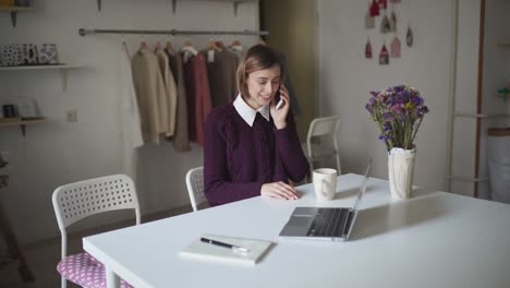 business woman working at home workplace. young woman calling on mobile phone