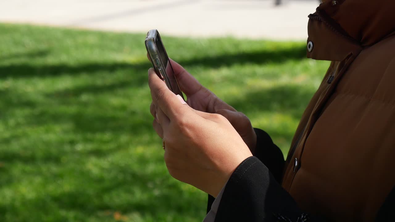 mujer usando un teléfono inteligente en un parque