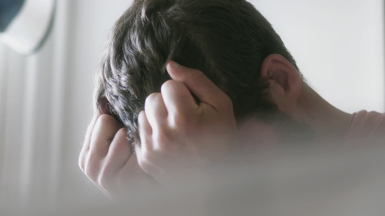 집에서 얼굴을 덮고 있는 우울한 백인 남자의 클로즈업 샷