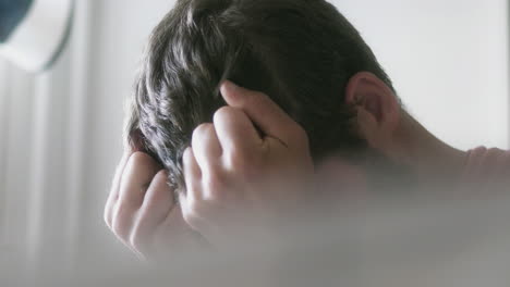 집에서 얼굴을 덮고 있는 우울한 백인 남자의 클로즈업 샷