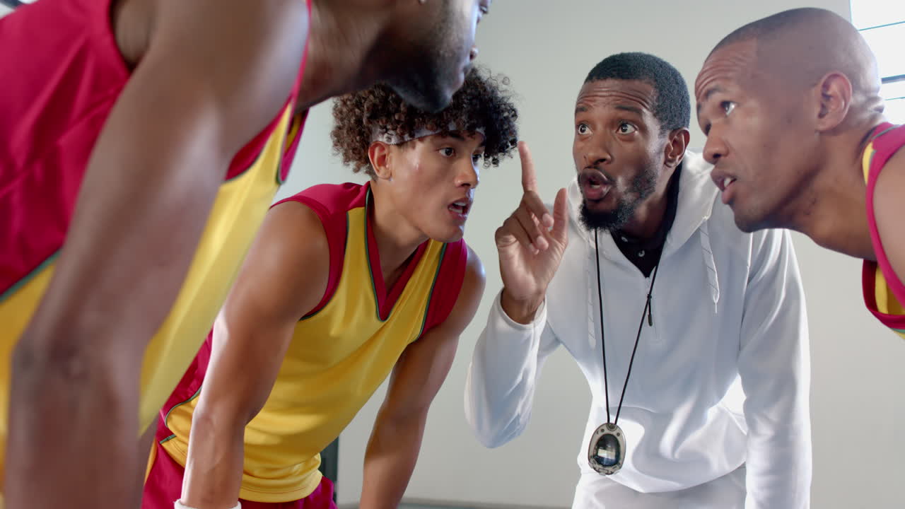 entrenador afroamericano instruye a jóvenes atletas biraciales y afroamericanos