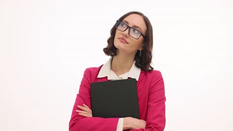 pensive businesswoman in pink blazer holding clipboard on white background
