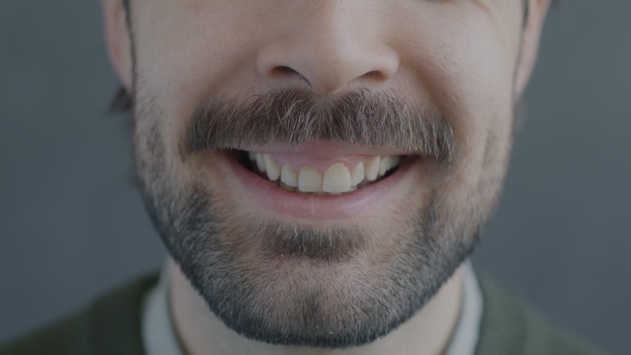 Close-up of a smiling man with a mustache and beard