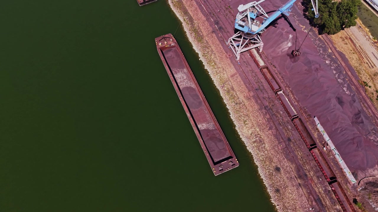 Vista di una chiatta e di un'area industriale vicino alla sponda di un fiume in estate