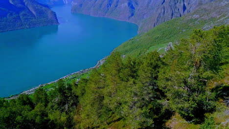 Amazing-aerial-of-turquoise-lake-in-the-lush-green-mountains-on-a-sunny-day