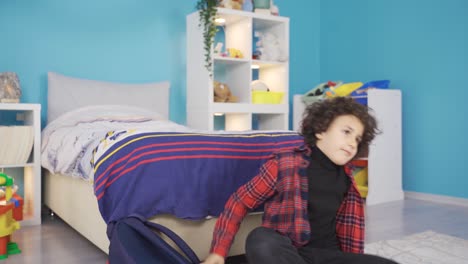 Boy-returning-home-from-school-sits-on-the-floor-tired-and-thoughtful.