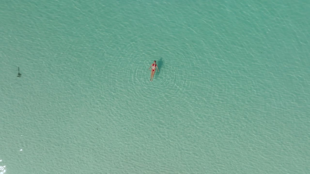 In The Spacious Seascape A Lady Floats Restfully In The Shallow Seawater