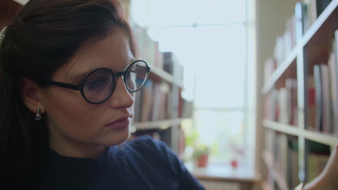 mujer buscando un libro en una biblioteca