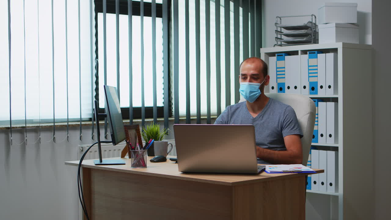 Mand med maske, der har online møde