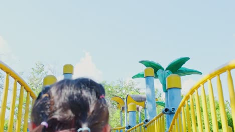 active little sisters are running in the outdoor playground in the park. happy child girls smiling and laughing on children playground. the concept of play is learning in childhood.