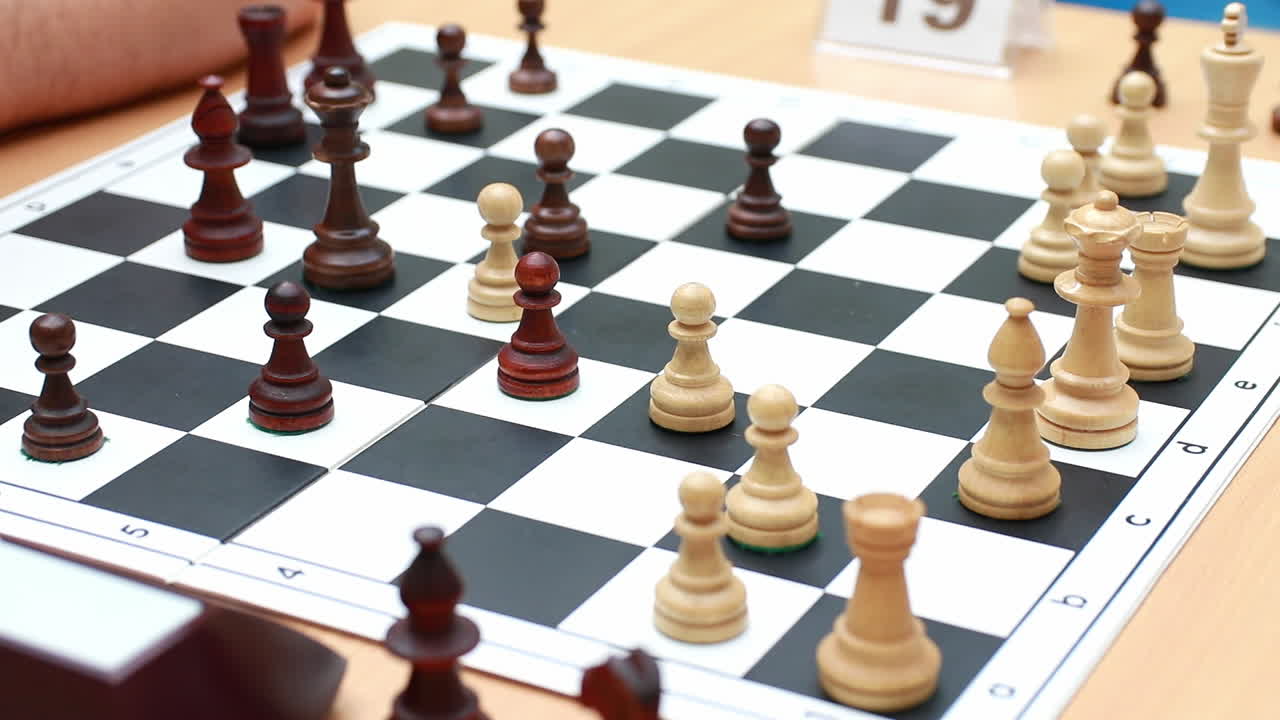 Unrecognizable people playing chess at the table. Concept of hobbies and board games, brain development and logic