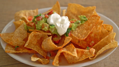 mexican nachos tortilla chips with jalapeno, guacamole, tomatoes salsa and dip