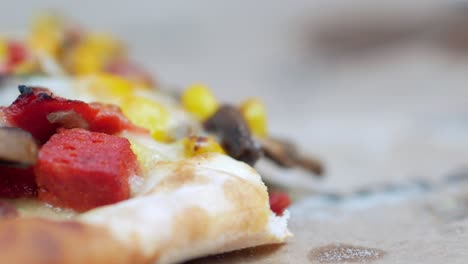 close up of a delicious pizza slice with corn, pepperoni, mushrooms, and cheese