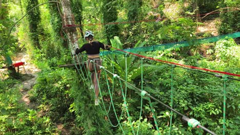 woman ziplining through tropical forest