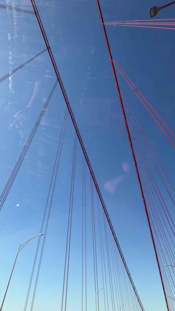 Guidando sotto un ponte sospeso rosso in una giornata di cielo sereno