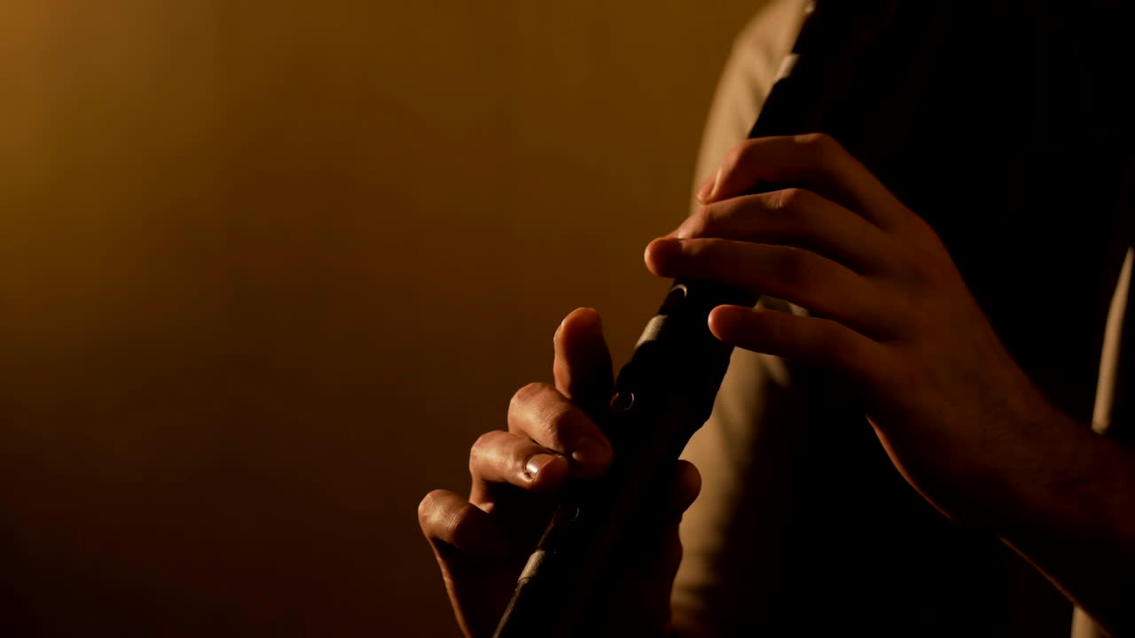 мужчина играет на японской бамбуковой флейте - шакухачи