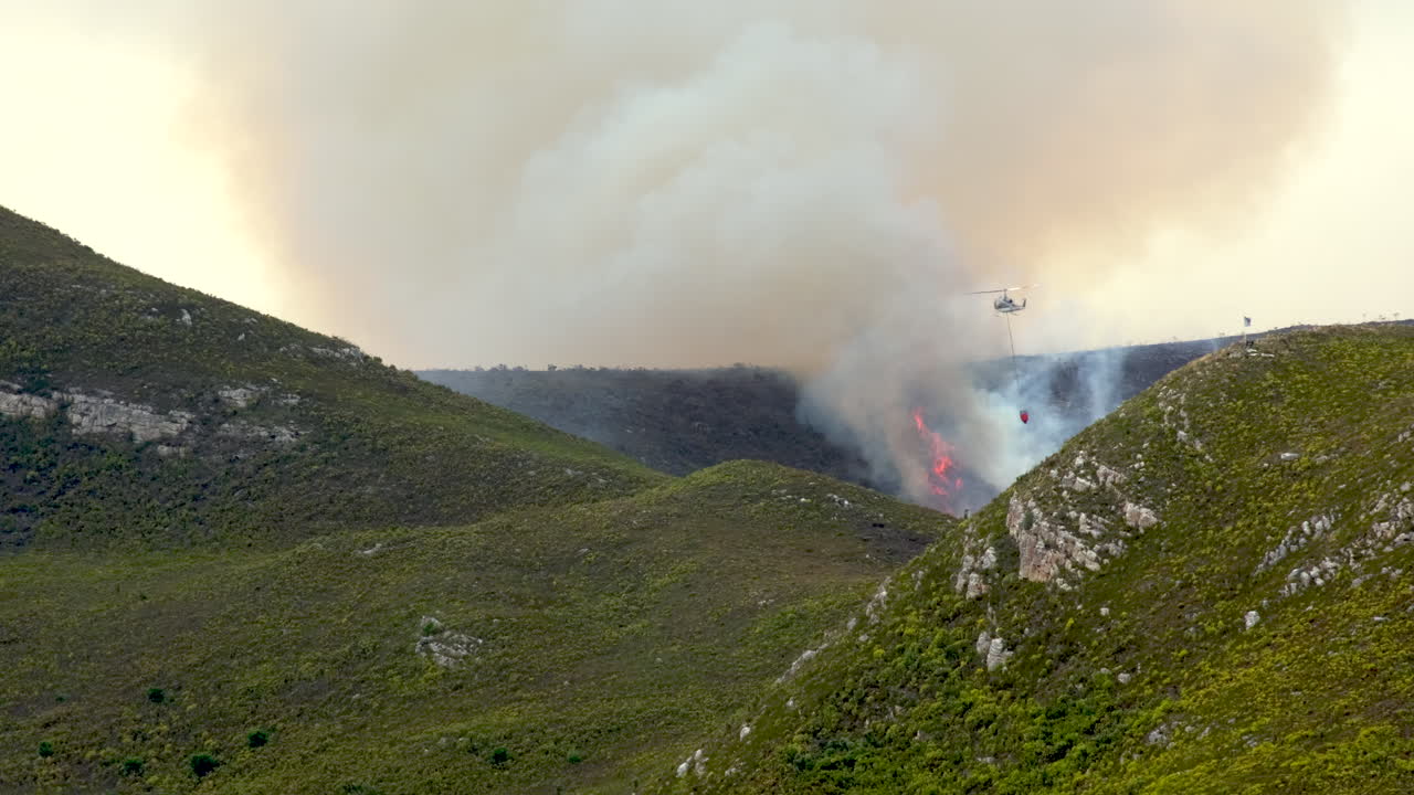Helicopter Fighting Wildfire in Mountainous Terrain