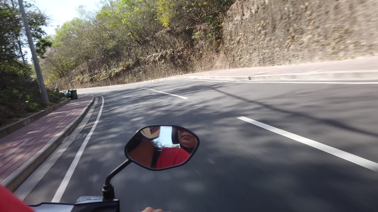 Two travelers driving motorbike in Bali Indonesia tropical background with amazing road. Searching for fun and beach on scooter main transportation system.