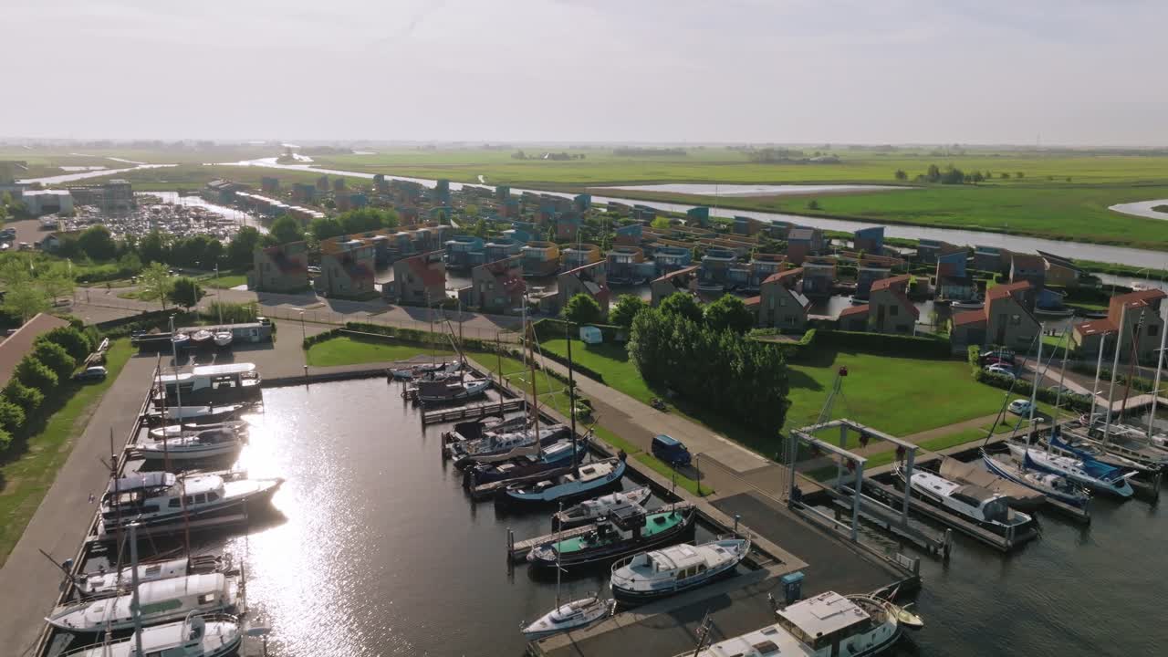 Drone pulls back to show colorful waterfront homes surrounded by canals and lush countryside