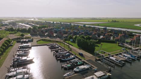 drone pulls back to show colorful waterfront homes surrounded by canals and lush countryside