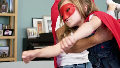 padre e hija fingiendo ser superhéroes