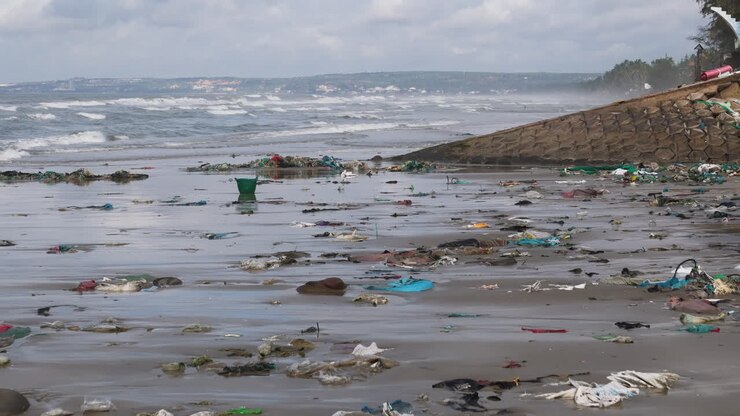 Waves crash against a beach covered in rubbish in Mui Ne Vietnam