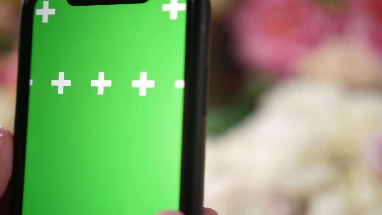 niña sostiene un teléfono inteligente iphone en las manos con una pantalla clave de croma de maqueta verde para el anuncio