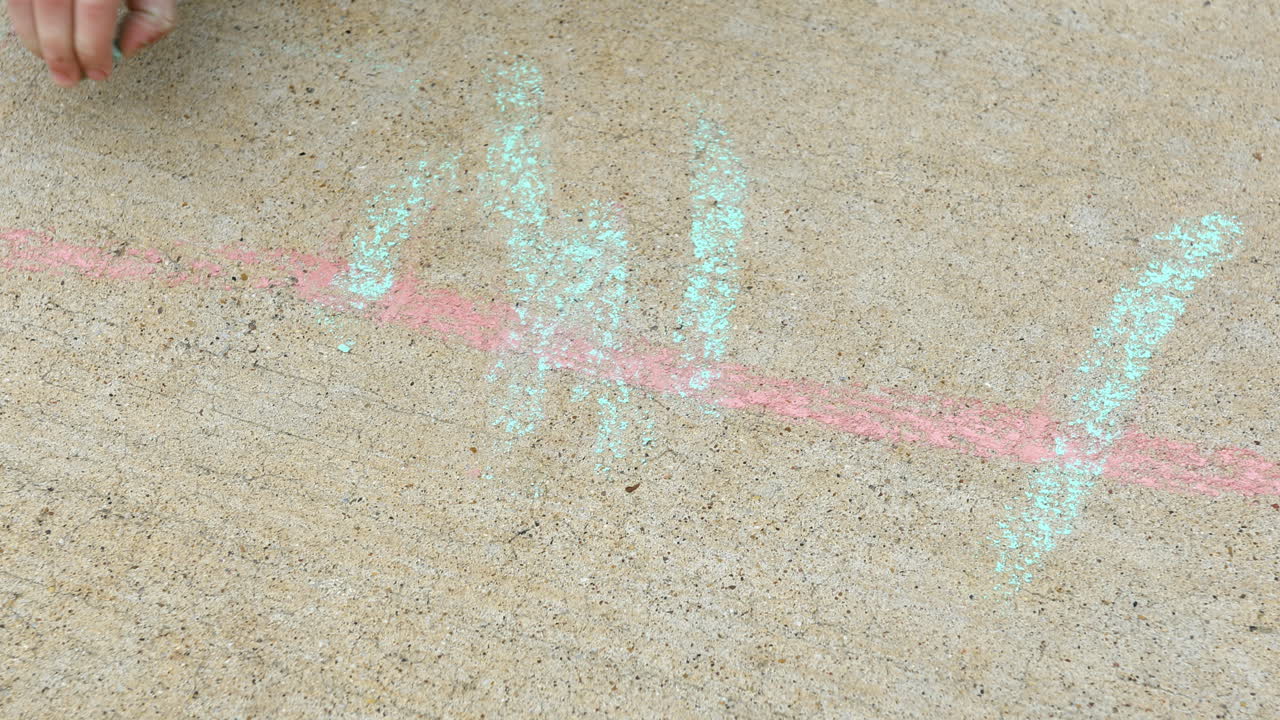 мальчик 4 лет рисует мелом на тротуаре