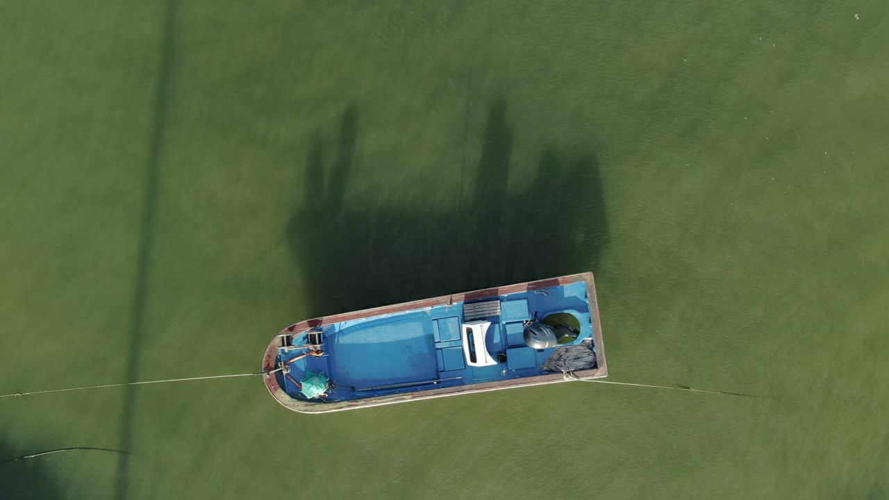 un pequeño bote azul que todavía está en el muelle