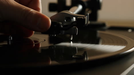 hand placing stylus on spinning vinyl record
