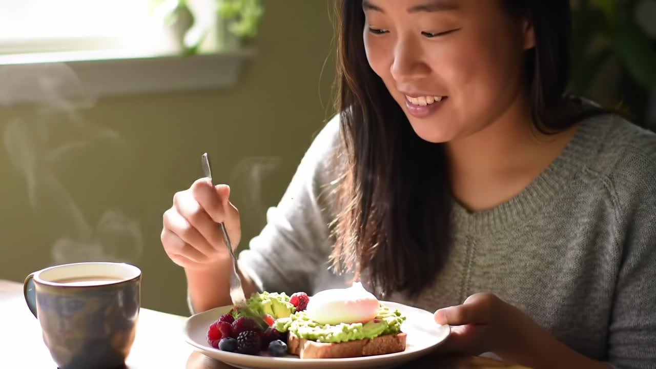 Enjoying a Delicious Breakfast: A Woman Relishes Her Avocado Toast with Soft Egg and Fresh Berries Alongside a Warm Cup of Coffee in a Cozy Setting