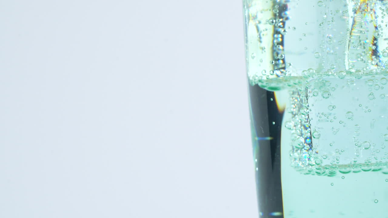 Extreme close up view of carbon dioxide bubbles in glass with fresh iced soda drink