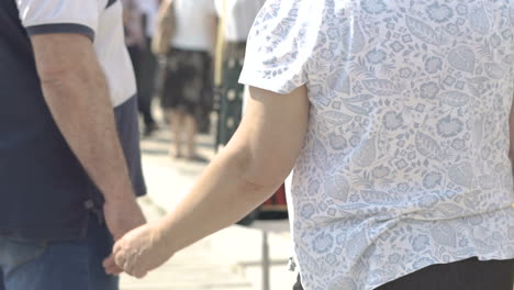 an elderly couple walks near the stalls of a fair