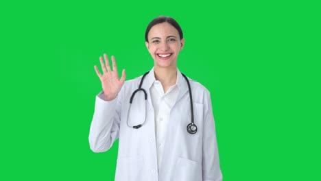 Happy-Indian-female-doctor-waving-Hi-to-the-camera-Green-screen