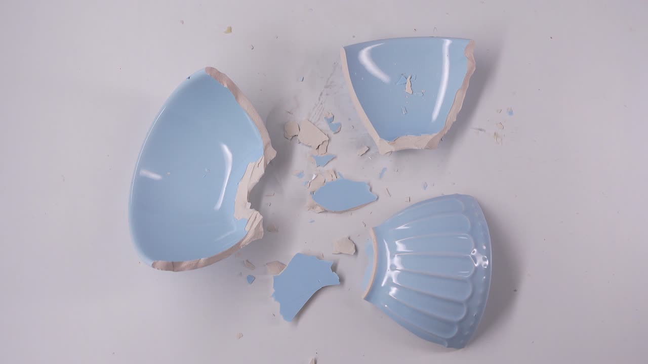 Broken Blue Ceramic Pot Shattered on White Background