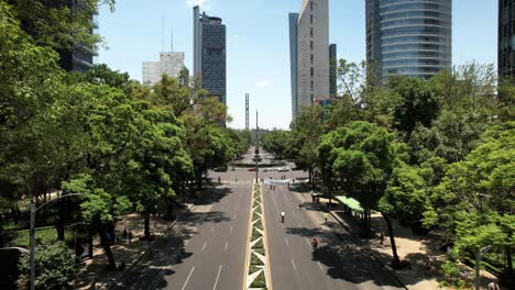 frontal drone shot of cyclists exercising on reforma avenue in mexico city during sunday