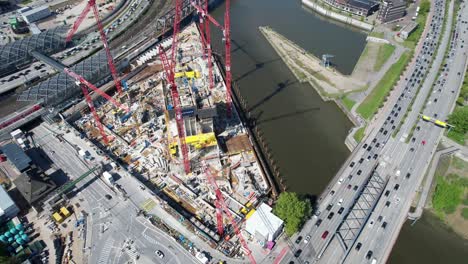 elbtower mid construction at midday with crane shadows on water, hamburg germany, aerial orbit