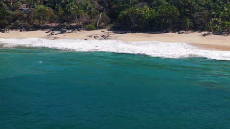 Drone-flying-along-hidden-beach-resort-in-Mexico