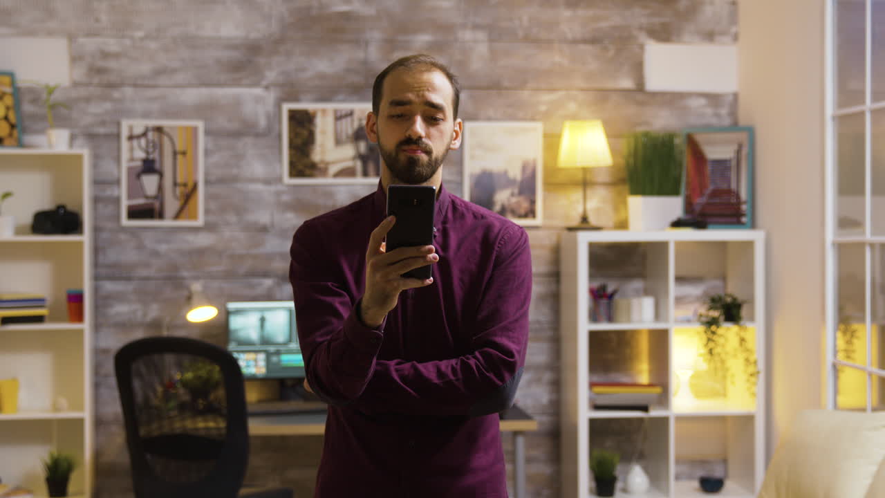 Un uomo usa un telefono in una stanza ben illuminata