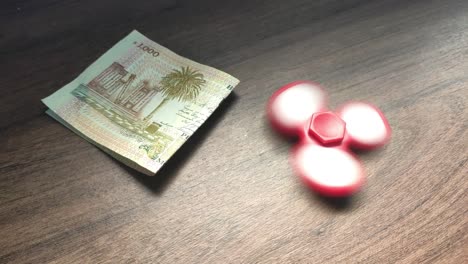 money and a fidget spinner on a table