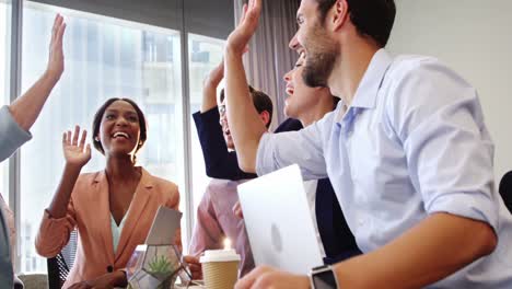 businesspeople interacting and giving high five to each other