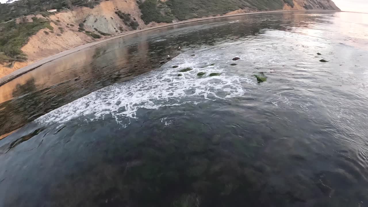 캘리포니아 랜초 팔로스 베르데스(rancho palos verdes)의 바다와 상징적인 해안 풍경은 일몰 때 1인칭 드론에서 물에 반사되는 다채로운 하늘과 함께 보입니다.