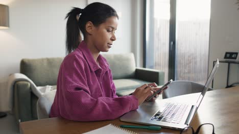 Frau-Surft-Auf-Dem-Telefon,-Während-Sie-Am-Computer-Arbeitet